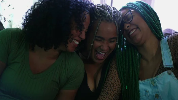 Girlfriends laughing together. Three black women smiling. Real life happiness emotion