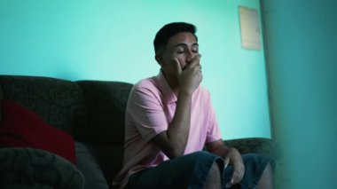 A frustrated young hispanic man covers face with hands feeling anxious. Preoccupied person