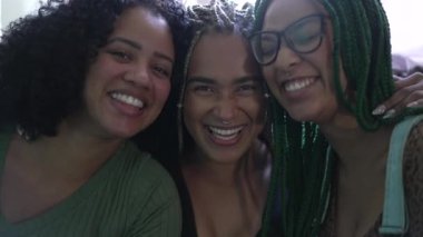 Portrait of three happy black latina women looking at camera smiling