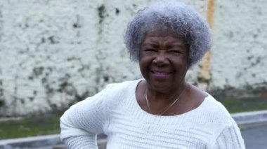 Güney Amerika caddesinde kameraya gülümseyen son sınıf bir kadın portresi.