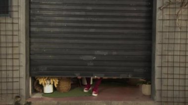 Yerel küçük işletme bayan sahibi dükkan kapısını açıyor. Sokak seviyesindeki çiçekçide duran kadın girişimci.