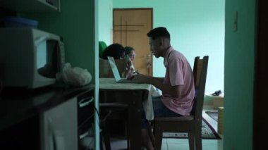 Candid young man browsing internet in front of laptop computer at home living room