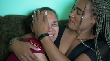 Adult daughter hugging older mother. An African girl embracing senior woman
