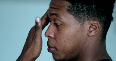Profile young black male touching face with hand