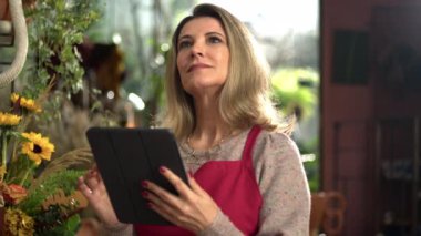 Portrait of female entrepreneur owner of Flore Shop holding tablet digital device
