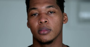 Portrait serious young black man looking at camera