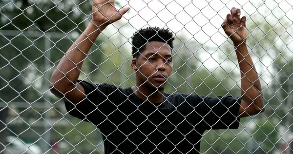 Pensive Black Guy Leaning Security Metal Fence — Stock Fotó