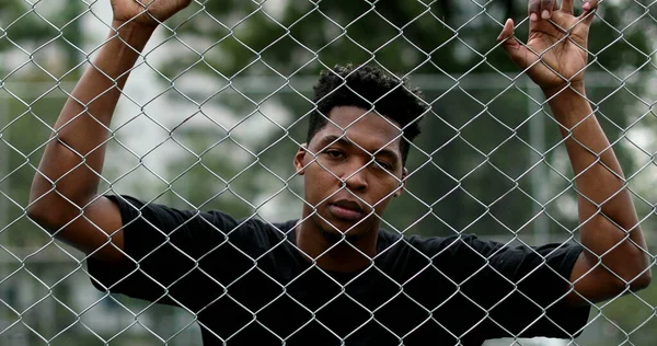 Pensive Black Guy Leaning Security Metal Fence — Stockfoto