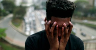 Anxious young black African man suffering in city
