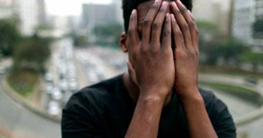Anxious young black African man suffering in city
