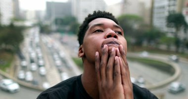 Anxious young black African man suffering in city