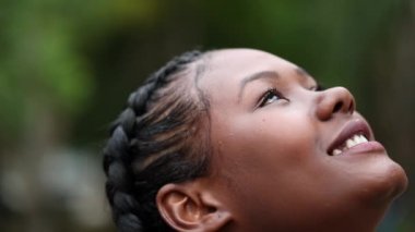 Umutla gökyüzüne bakan güzel bir kız. Çeşitli Afrikalı genç kadınlar FAITH 'le yakın çekim bakışlarla karşılaşıyorlar