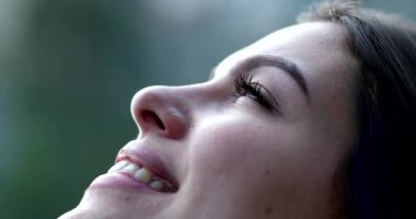 Mutlu kadın umut ve inançla gökyüzüne bakıp gülümsüyor.