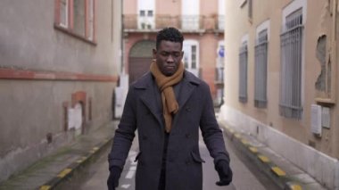 Upset black male clapping hand in anger while walking in city