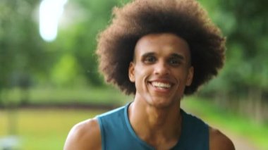 Smiling happy black man walking towards camera laughing and casual