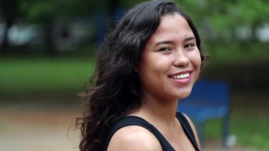 Dışarıda kameraya gülümseyen İspanyol genç bir kadın, açık havada sıradan bir kız. Gerçek insanlar dizisi