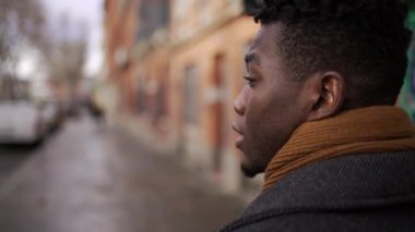 Back of black walking outside in city sidewalk downtown. African person perspective