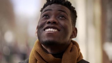 Siyah adam gökyüzüne bakıyor umutla ve inançla gülümsüyor