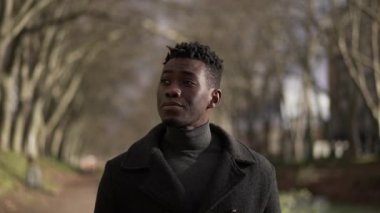 Contemplative young black African man walking outside