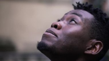 Genç Afrikalı adam UMUT ve FAITH ile yakından bakıyor.