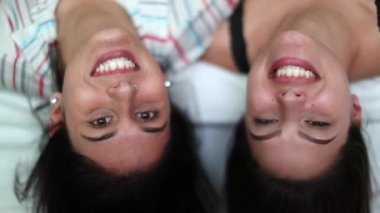 Baş aşağı duran iki bayan arkadaş. En iyi arkadaşlar gülüyor ve gülümsüyor