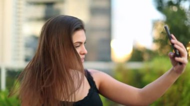 Güzel milenyum kızı cep telefonuyla selfie çekiyor.