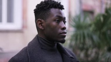 Dışarıda dikilen ciddi bir zenci. Acımasız yakışıklı Afrikalı