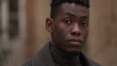 Afrikalı adam kameraya bakıyor.