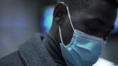 Siyah adam covid-19 yüz maskesi takıyor.
