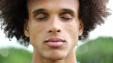 Gözleri kapalı genç siyah bir adam.