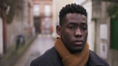 Contemplative black African male walking in city back alley