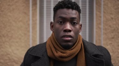 Portrait young black man staring at camera outside in urban european city town