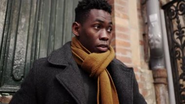Young black man steps outside walking in city