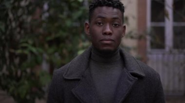 Siyah Afrikalı genç adam kameraya gülümsüyor, portre yüzlü.