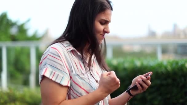 Woman Celebrating Good News Her Mobile Phone Punching Air Her — Vídeo de stock