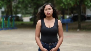 Genç İspanyol kadının dramatik bir görüntüsü. Dışarıda durmuş, fotoğraftaki resme bakıyor.