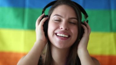 Arka planında LGBT gökkuşağı bayrağı olan mutlu milenyum kadınları