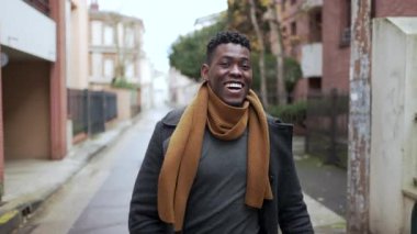 Black man celebrating success raising fist in the air. Successful African guy walking in city
