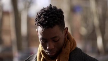 Pensive Young black African man walking outside in city