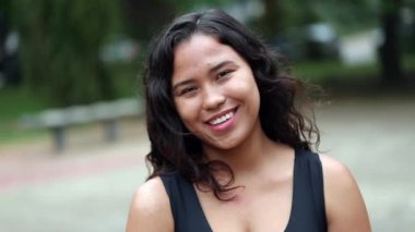 Sıradan İspanyol genç bir kadın kameraya gülümsüyor. Mutlu Latin kız, takip çekimi.