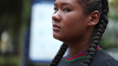 Siyahi Afrikalı kadının dışarıdaki kameraya yakından çekilmiş yüz resmi.
