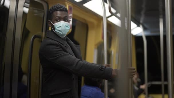 African Man Adjusting Face Mask While Commuting Train Holding Bar — ストック動画