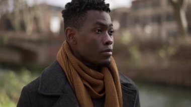 Young black man walking outside in nature during winter season