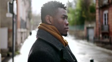 Black man standing outside in city during winter season