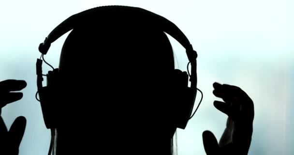 Повернення Жінки Надягає Навушники Силует Людини Слухає Музику Пісню Подкаст — стокове відео