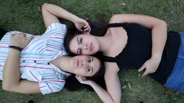 Two Millennial Girlfriends Lying Grass Looking Camera — Video