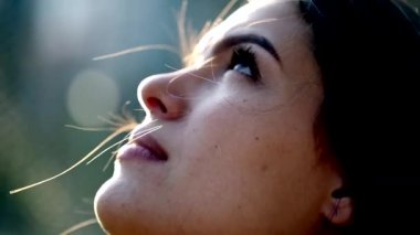 Young woman face looking up to the sky in slow-motion