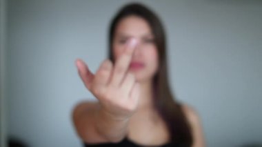 Güzel kız kameraya orta parmağını gösteriyor. Orta parmağını gösteren genç bir kadın.