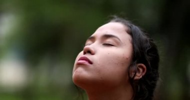 Doğada gözlerini açan genç bir kadın özgürlüğü hissediyor. Düşünceli kız, gözlerini yakın çekimde açar.