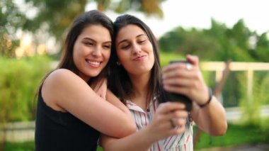 Millennial women taking selfie photo with cellphone outside